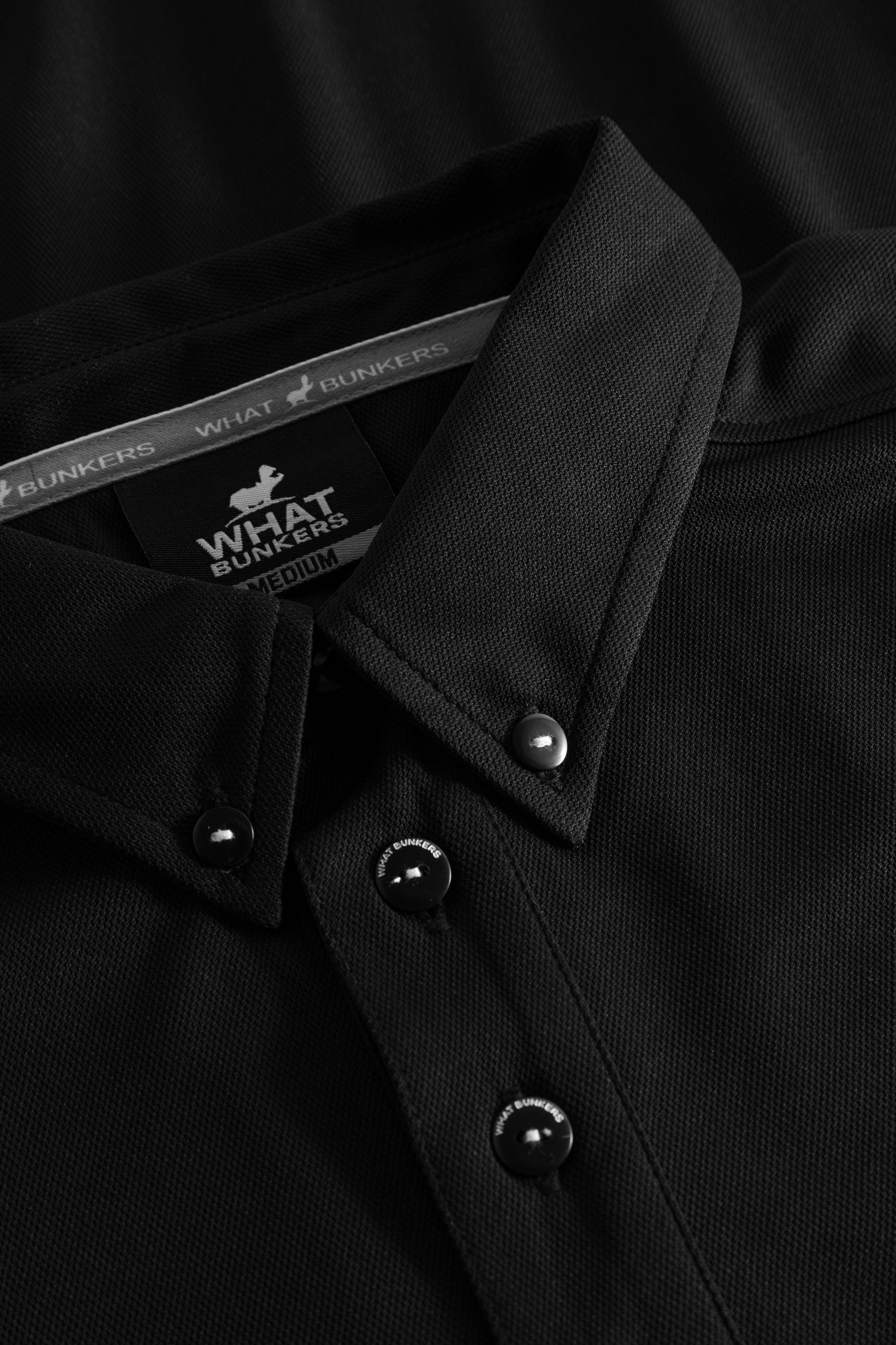Black golf polo shirt with a buttondown collar and hippo detals.